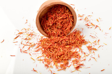 Fototapeta premium Iranian red saffron spice in wooden bowl isolated on white background