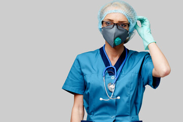 female doctor with stethoscope wearing protective mask and latex gloves over light grey background