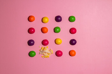 Broken candy among whole ones on color background. Concept of uniqueness