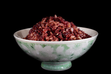 Thai riceberry mixed Thai jasmine rice in bowl on a black background.