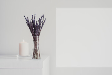 Dried lavender in a small vase and one burning candle. Minimal and simple home decor. Aromatherapy...