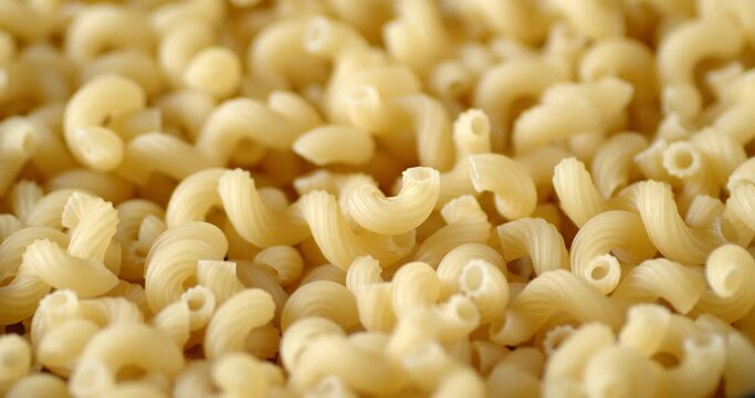 Cavatappi pasta dry rotates slowly on the table.