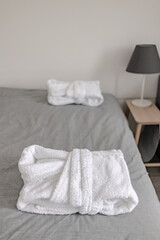 Fototapeta na wymiar White terry bathrobes on the bed in a white Scandinavian bedroom 0060