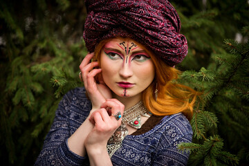 Portrait of a young beautiful girl in a turban in the autumn garden.