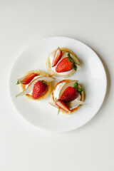Healthy and hearty breakfast: cheese pancakes with sour cream, decorated with slices of strawberries and pears
