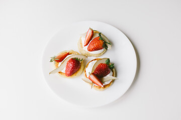 Cottage cheese pancakes with cream, pear, strawberries. 