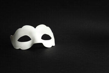 Naklejka premium White masquerade mask on a black background