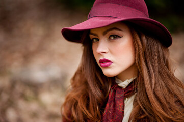 Portrait of a young beautiful girl in a hat in autumn park.