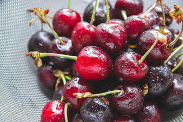 Marco picture of red cherries with water drops. Natural tasty picture, as flat lay concept. Close up picture of fruit from the garden with bright shade. Healthy copy space.