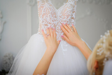 Attractive bride touches her wedding dress. The inscription on the back of the bride in romanian...
