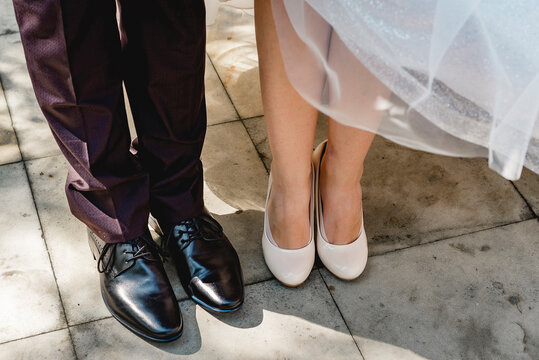 Shoes on the feet of the bride and groom on a wedding day