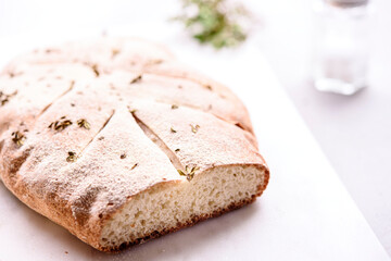 Homemade fresh baked Fougasse (French Bread) with thyme and olive oil on white background. Traditional Provencal dishes. Selective focus