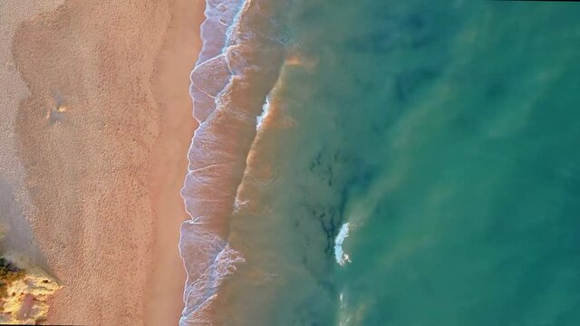 Drone flight over empty Gale beach in Portugal with top view on shoreline