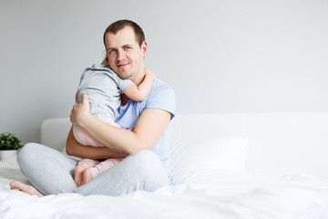 family, love and father's day concept - portrait of happy young father embracing his cute little daughter