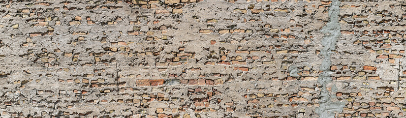 wide brick wall with dirty rough stucco. Panoramic view. layout design.