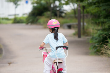 夏の公園で自転車を乗っている子供