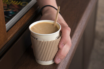 Hand holding a glass with natural coffee