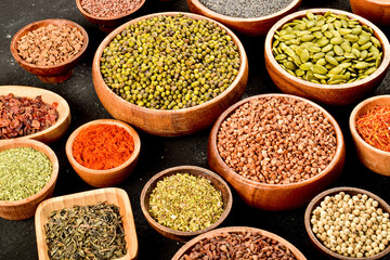 Different kinds of colorful spices in wooden bowls. Top view of spices.