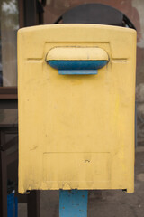 Yellow-blue mailbox hanging on the street