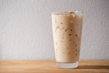 Glass of ice coffee milk on wooden table. Cold beverage background. Refreshment food.
