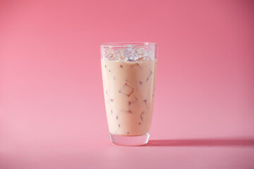 Glass of ice coffee milk on pink background. Cold beverage tasty. Refreshment food.