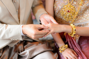 Bride and Groom putting wedding ring on finger, Thai wedding engagement ceremony