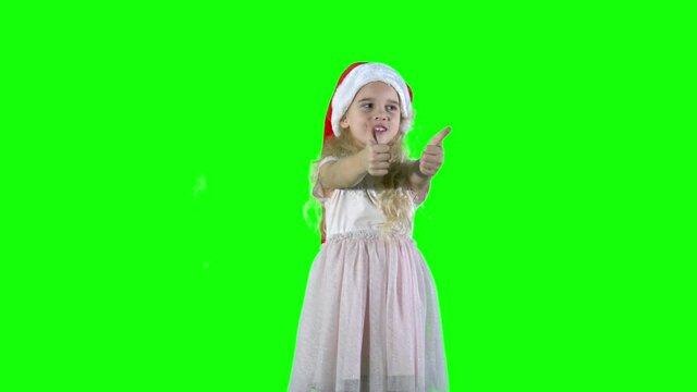 Pretty child with curly blond hair play-act simper with Christmas hat cap.