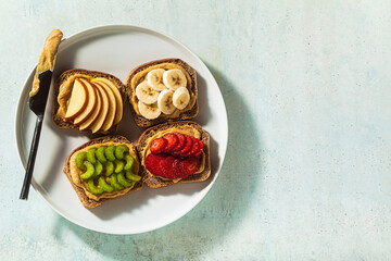 various sandwiches with peanut butter and strawberries, celery, banana and apple on a plate on the...