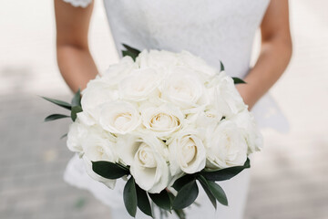 Obraz na płótnie Canvas bride holding bouquet of flowers. white roses close-up