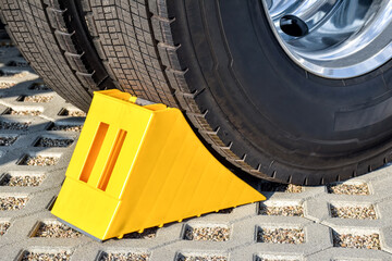 Yellow chock at the wheel of a parked truck