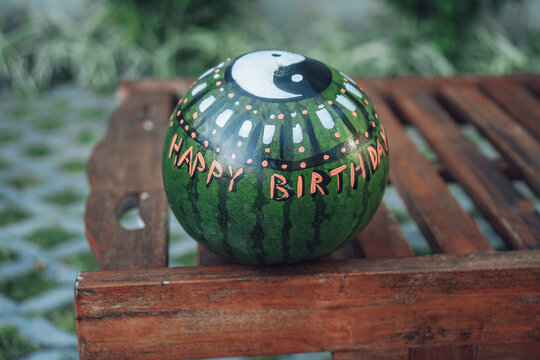 green watermelon with the image of the symbol Yin and Yang and the inscription happy birthday