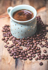 coffee cup and coffee beans on old wooden table. Vintage style