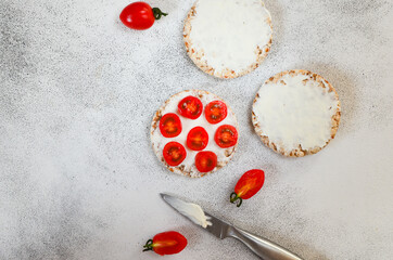 Cooking crispbreads with cottage cheese and cherry tomatos. Hearty snack and vegetarian food lifestyle