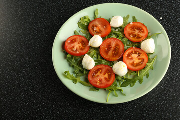 salad of tomatoes, herbs and mozzarella on a plate top view