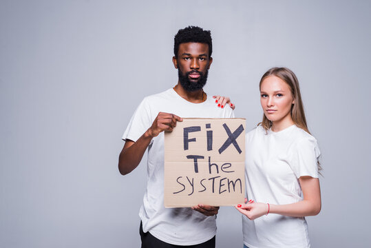 Young african man and coucasian woman holding a cardboard poster with the message text Fix the system isolated on white background. Concept on the theme of protest for police brutality and racism.