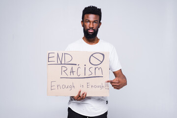 Young african man and coucasian woman holding a cardboard poster with the message text END RACISM...