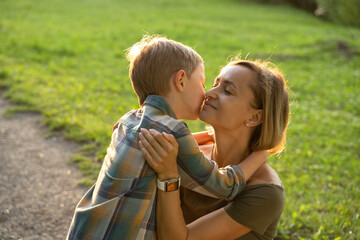 Obraz premium Beautiful young mother with little son walking in the park after a rain.