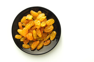 Large light raisins in a black plate.