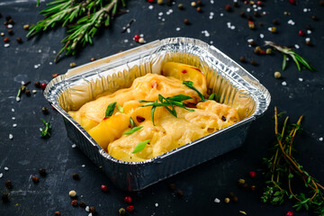potatoes with cheese in a container, takeaway
