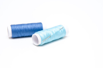 Fototapeta na wymiar Blue sewing threads on a white background.