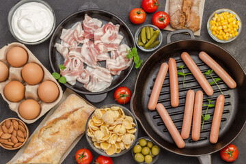 Sausages in pan. Bacon cheese, vegetables, cookies cereal yogurt: ingredients for  continental breakfast