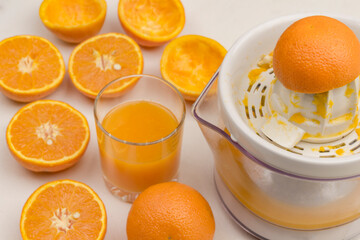 Peel of fresh orange on juicer. Glass of juice and oranges