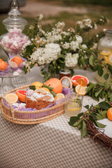 Fototapeta na wymiar Muffins in a fruit basket. Picnic in the Park on the green grass with fruit, Lemonade