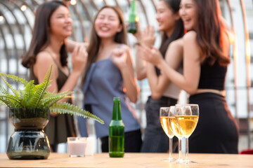 Selective focus of champagne glasses with blurred happy group of friends