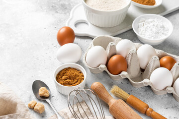 Fototapeta na wymiar Ingredients for baking on a culinary background. Eggs, flour, cinnamon, sugar, soda on the kitchen table. Concept of preparation for baking. Top view with space for text