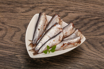 Anchovies in the bowl served basil leaves