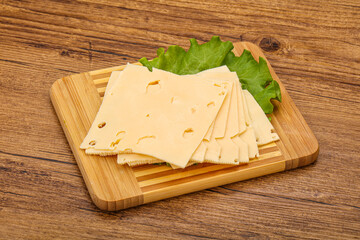 Sliced yellow cheese over board