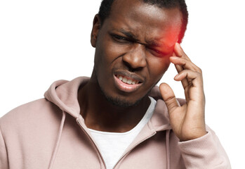 Close-up portrait of african american man suffering from severe headache, pressing finger to temple, closing eyes in order to relieve pain with helpless face expression, isolated on white background