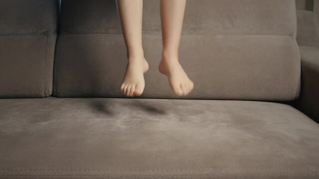 The child is dancing with joy. Children's feet jump and dance. Childhood happiness