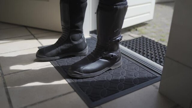 Putting on motorcycle boots before driving.